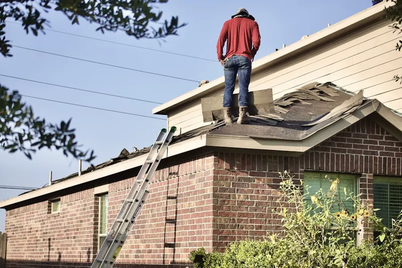 Professional roofer working on a residential roof in Ashmont
